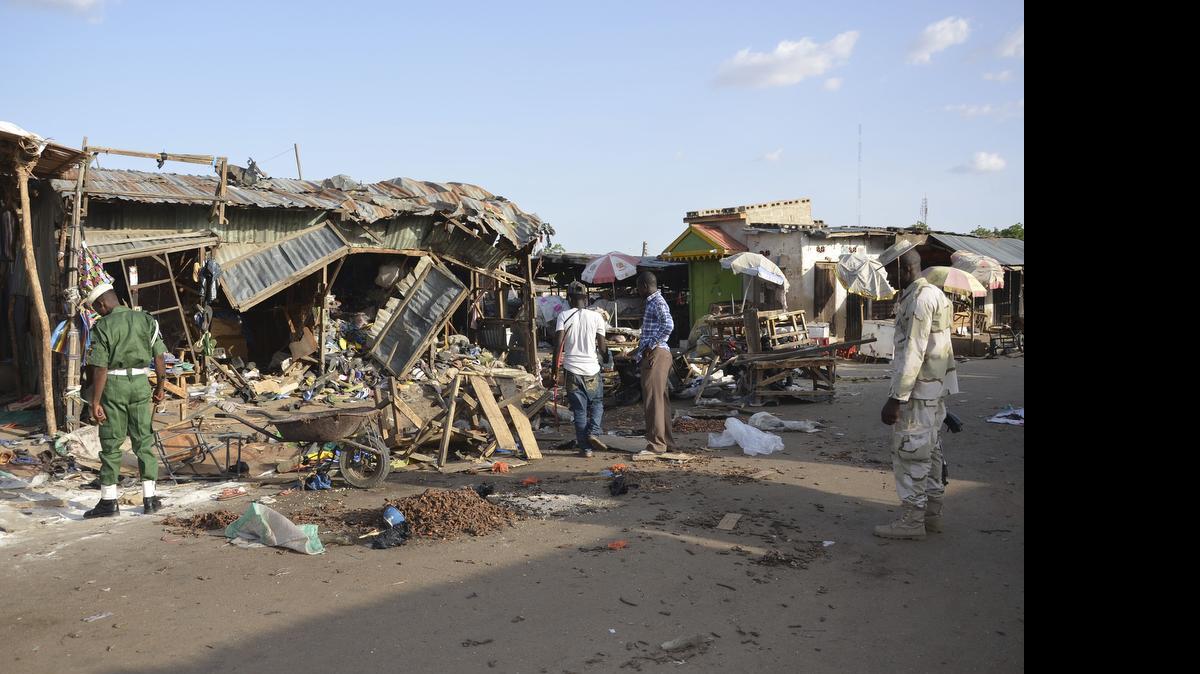 
People gather at the site of a suicide bomb attack at a market in Maiduguri, Nigeria, on June 22, 2015. A teenage girl strapped with explosives ran away from a crowded mosque this week, killing only herself and cementing suspicions that Boko Haram is using unwilling captives in its terror campaign in northeast Nigeria. The girl took off after her companion blew up in an explosion that killed 30 people on Monday in Maiduguri, the biggest city in northeast Nigeria, witnesses and a mortuary worker said.
