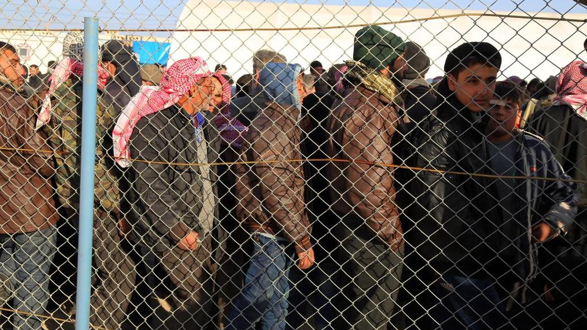 In this photo provided by Turkey’s Islamic aid group of IHH, Syrians fleeing the conflicts in Azaz region, queue at the Bab al-Salam border gate on Friday, Feb. 5, 2016. 