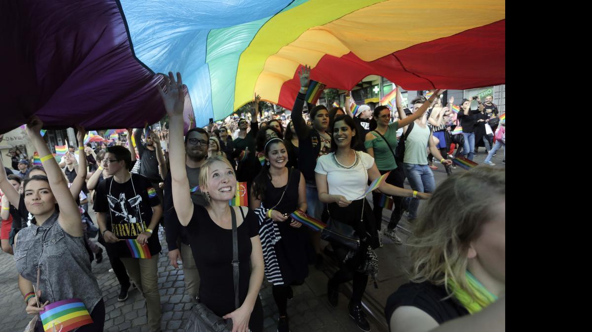 
Demonstrators sing and dance under a giant rainbow flag during the Sofia Gay Pride Parade in Sofia, Saturday, June 27, 2015. Hundreds paraded through the Bulgarian capital of Sofia under rainbow-colored balloons and banners for that city’s eighth Gay Pride march on Saturday. They were flanked by police in the wake of calls by some extremist groups to stop the rally.
