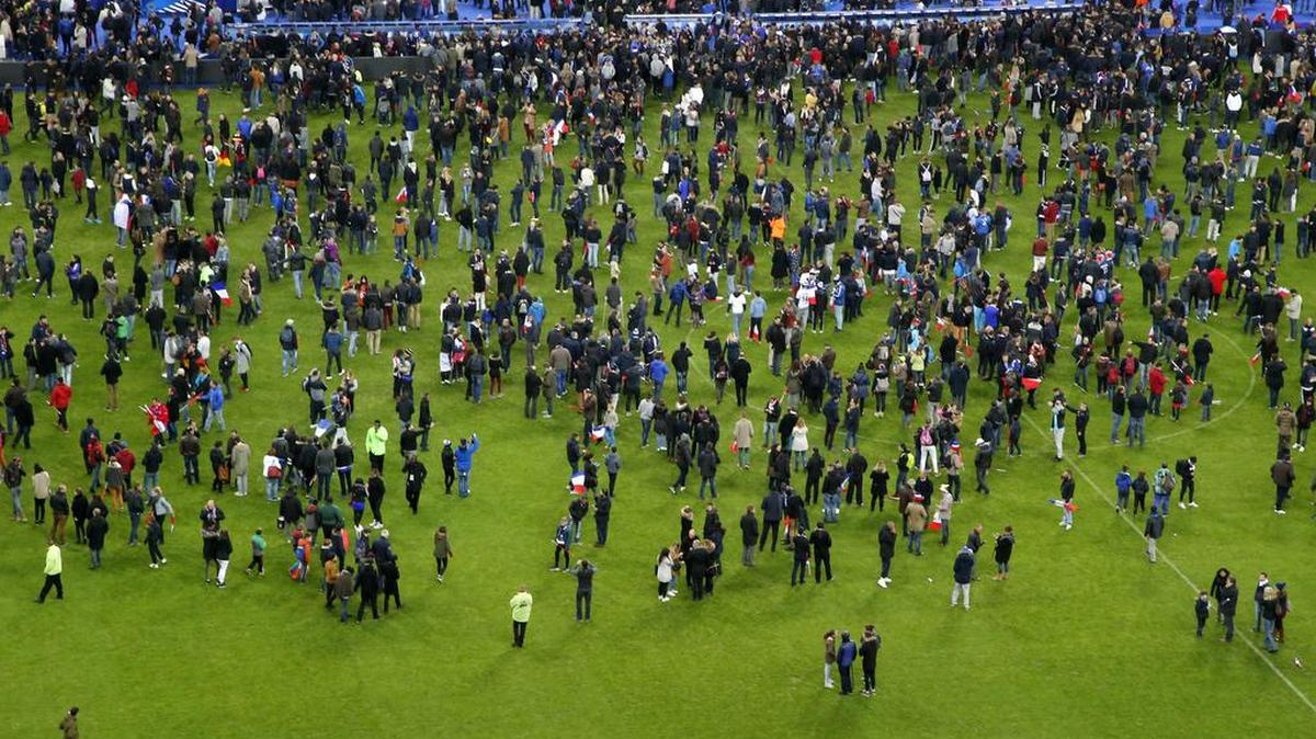 Spectators invade the pitch of the Stade de France stadium after the international friendly soccer France against Germany, Friday, Nov. 13, 2015 in Saint Denis, outside Paris. At least 35 people were killed in shootings and explosions around Paris, many of them in a popular theater where patrons were taken hostage, police and medical officials said Friday. Two explosions were heard outside the Stade de France stadium.
