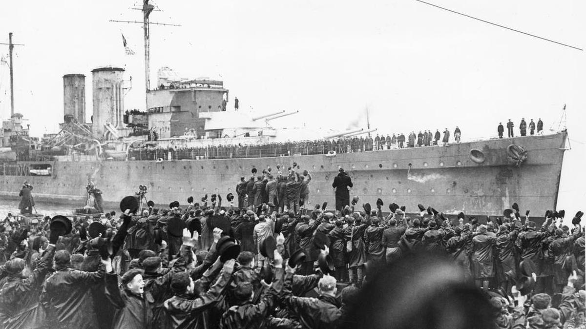 British cruiser H.M.S. Exeter being cheered by sailors and dock workers as she is brought alongside the quay at Plymouth, England, on Feb. 15, 1940.