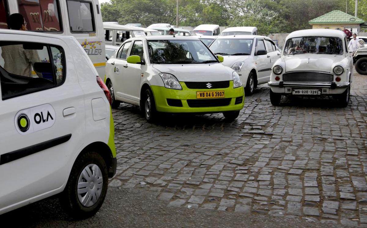 In this March 29, 2016 photo, Ola cabs, left, waiting for customers are parked next to other cars in Kolkata, India. Aiming to wrest control of India’s booming taxi market, two cab-hailing smartphone apps, Uber and Ola, are promising hundreds of millions in new investments while also facing off with one another in court.
