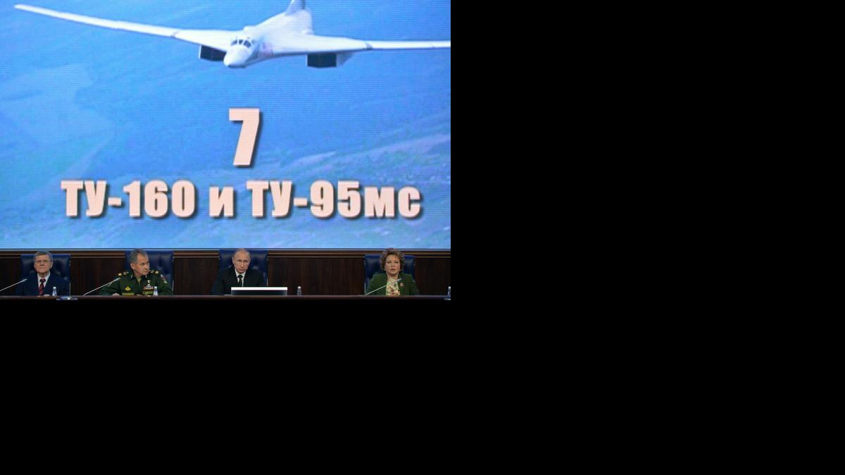 
Russian President Vladimir Putin, second right, Defense Minister Sergei Shoigu, second left, lead a meeting with top military brass in Moscow, Russia, Friday, Dec. 19, 2014, with the picture of supersonic strategic bomber is on the huge screen. 
