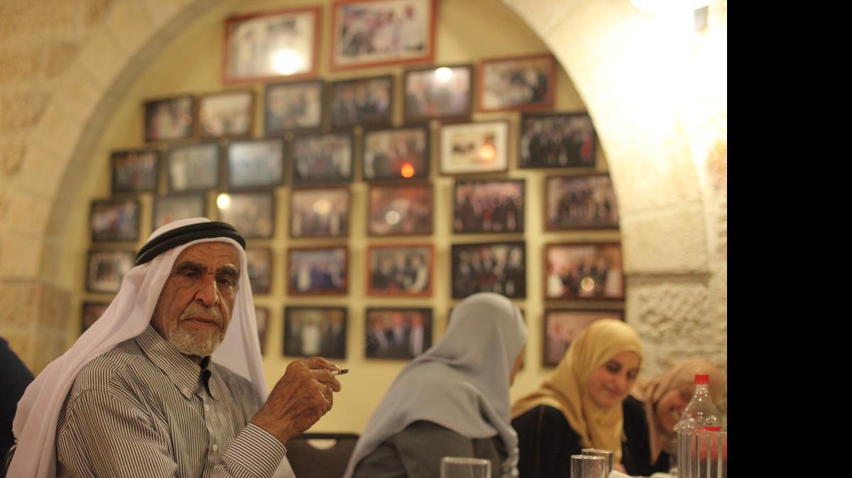 
In Ramallah's Darna restaurant, guests drink coffee under photographs of Jimmy Carter, Yasser Arafat and other past visitors at the end of the Iftar meal that breaks the daily Ramadan fast on July 9, 2015.
