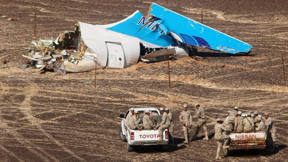 In this photo made available Monday, Nov. 2, 2015, and provided by Russian Emergency Situations Ministry, Egyptian Military on cars approach a plane's tail at the wreckage of a passenger jet bound for St. Petersburg in Russia that crashed in Hassana, Egypt, on Sunday, Nov. 1, 2015. The Russian cargo plane on Monday brought the first bodies of Russian victims killed in a plane crash in Egypt home to St. Petersburg, a city awash in grief for its missing residents.