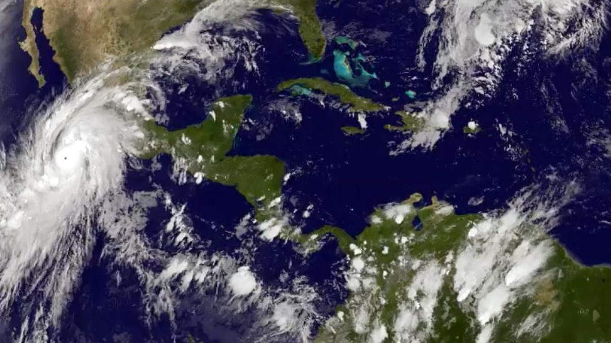 This satellite image taken at 8:45 p.m. EDT on Thursday, Oct. 22, 2015, and released by the National Oceanic and Atmospheric Administration shows Hurricane Patricia, left, approaching Mexico’s central Pacific Coast.