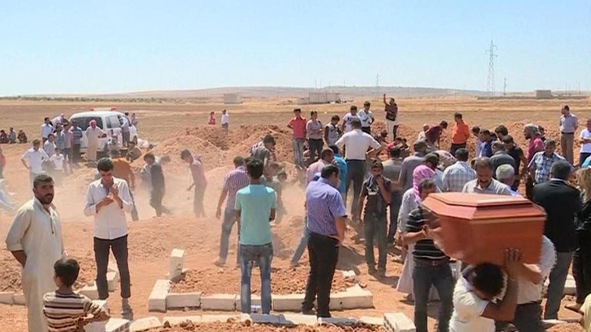 
In this image made from video, mourners carry a coffin during the burial of Rehan Kurdi and her sons Aylan, 3, and Galip, 5, after they drowned during a desperate voyage from Turkey to Greece, in their hometown of Kobani, the Syrian Kurdish region they fled, on Friday, Sept. 4, 2015. The haunting image of 3-year-old Aylan Kurdi, washed up on Turkish beach focused the world's attention on the wave of migration fueled by war and deprivation. Their boat capsized while trying to reach the island of Kos. 
