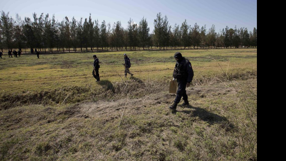
Police comb a field for evidence in the Rancho del Sol, a ranch in the municipality of Ecuandureo, Mexico, Saturday, May 23, 2015. The latest in a series of clashes between Mexican authorities and a powerful, fast-growing drug cartel turned into the deadliest confrontation in recent memory, with 42 suspected gang gunmen and one Federal Police officer killed on Friday during a three-hour firefight at this remote western ranch. 
