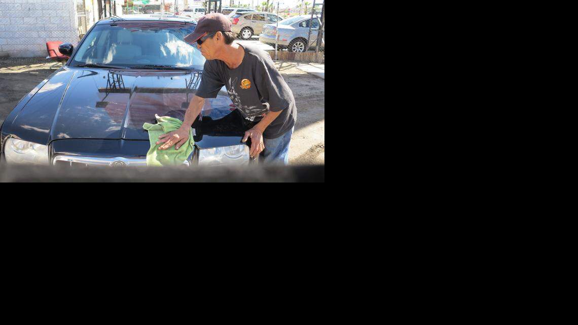 Worker Carlos Buelna cleans up a Chrysler at a used car lot in Mexicali, Mexico, on March 4, 2015. Mexico has been flooded with some 7.5 million used cars from the United States in the past decade.