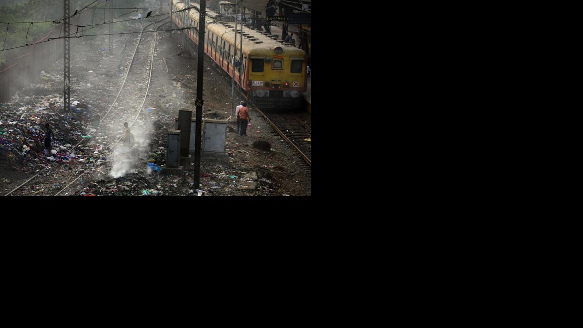 
In this Monday, Jan 26, 2015 file photo, a local train moves past burning garbage at a local train station in Mumbai, India. India’s filthy air is cutting 660 million lives short by about three years, while nearly all of the country’s 1.2 billion citizens are breathing in harmful pollution levels, according to research published Saturday, Feb. 21, 2014. While New Delhi last year earned the dubious title of being the world’s most polluted city, the problem extends nationwide, with 13 Indian cities now on the World Health Organization’s list of the 20 most polluted. 
