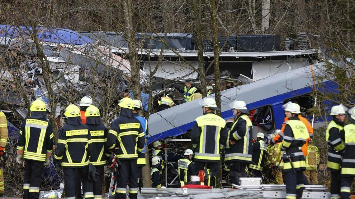 Rescue personnel stand in front of two trains that collided head-on near Bad Aibling, southern Germany, Tuesday, Feb. 9, 2016. Several people have been killed and dozens were injured.