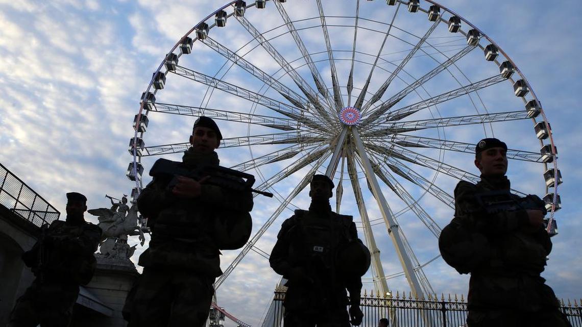 French soldiers patrol in front of the Paris ferris Big Wheel next to the Champs Elysees, in Paris, on Sunday, Nov. 22, 2015 one week after the Paris attacks. French Defense ministry announced that there are currently 10,000 soldiers deployed in France as part of security measures put in place in the wake of the attacks, including 6,500 in the Paris region.