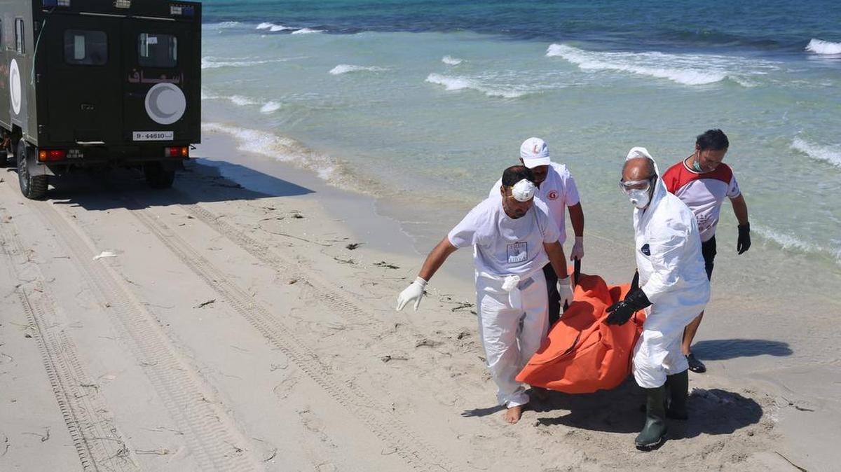 
In this Sunday, Aug. 30, 2015 photo, Libyan Red Crescent workers carry the body of a drowned migrant who washed up along with several others in Zuwara, Libya (65 miles west of Tripoli) after two smuggling boats sank off the coast of Libya on Thursday. Search teams found more than ten bodies that had washed ashore - about 500 migrants were believed to be on board the two boats, according to rescue teams.
