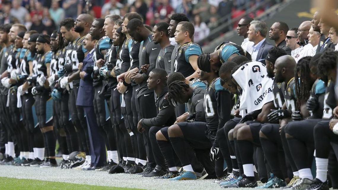 Jacksonville Jaguars players lock arms and kneel down during the playing of the U.S. national anthem before an NFL football game against the Baltimore Ravens at Wembley Stadium in London on Sunday.
