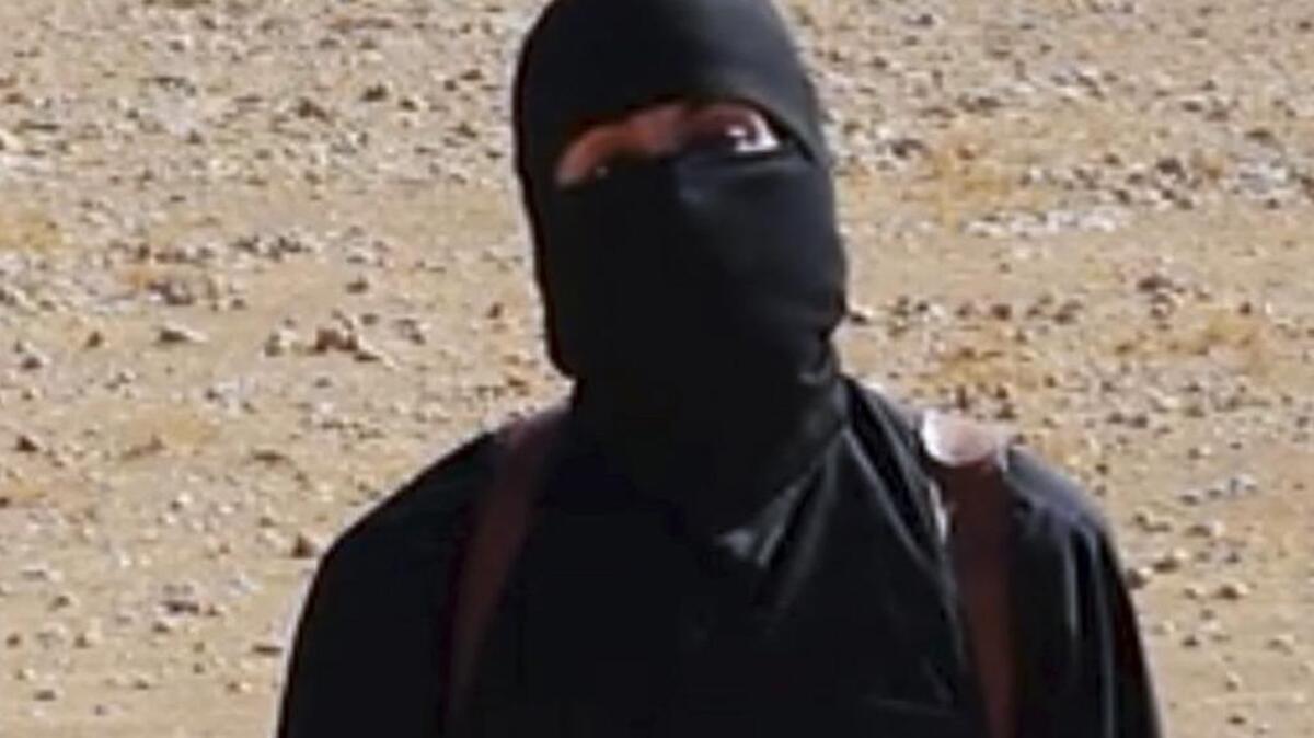 This undated image in a frame from a video released Oct. 3, 2014, by Islamic State militants purports to show the militant who beheaded taxi driver Alan Henning.
