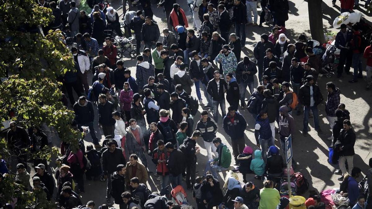 In this Oct. 1, 2015, picture hundreds of migrants wait for their registration at the central registration center for refugees and asylum seekers, in Berlin, Germany. Berlin police say Thursday Oct. 29, 2015, they have arrested a suspect in the disappearance earlier this month of 4-year-old Bosnian boy Mohamed Januzi leaving the central registration center for migrants in Berlin, and have found the body of a child in the suspect's car.