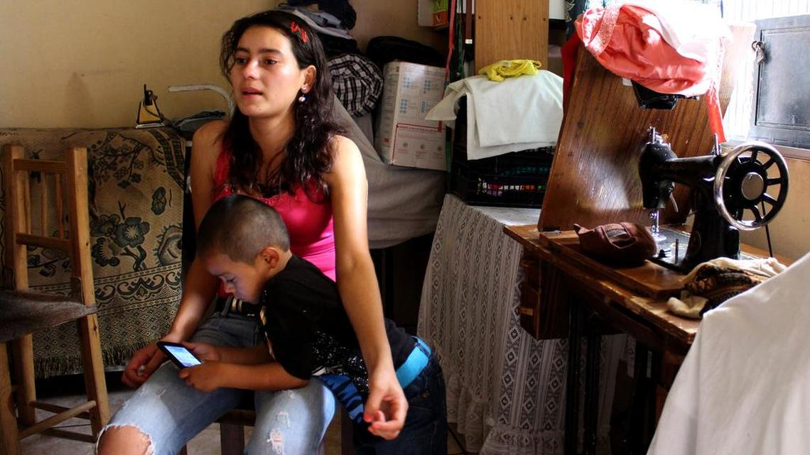 
Lilian Oliva Bardales, aged 19, sits while her son, Cristian, aged 4, plays with her mobile phone in the small living room at a relative's house in a community of Tegucigalpa, Honduras on June 15, 2015. Oliva and her son fled Honduras last week and are now living in Western Europe.
