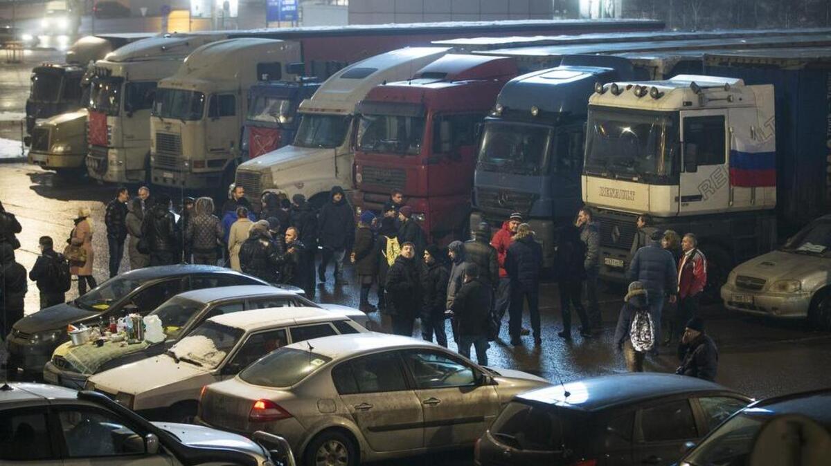 Truck drivers and their supporters walk among parked trucks outside Moscow, Russia, on Friday. In a hurried attempt to placate truck drivers protesting the new road toll for long-distance haulers as too high, the Kremlin-controlled parliament on Friday eased fines under a new road bill and indicated that it was ready to make further concessions.