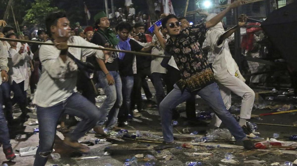 Protesters throw sticks and mineral water bottles during a clash with the police outside the presidential palace in Jakarta, Indonesia, on Nov. 4, 2016. Indonesian police on Wednesday, Nov. 16, 2016 named the minority Christian governor of the country’s capital as a suspect in a blasphemy investigation in a major test of the Muslim-majority nation’s reputation for religious tolerance. Earlier this month the capital Jakarta was rocked by a massive protest by conservative Muslims against the governor.