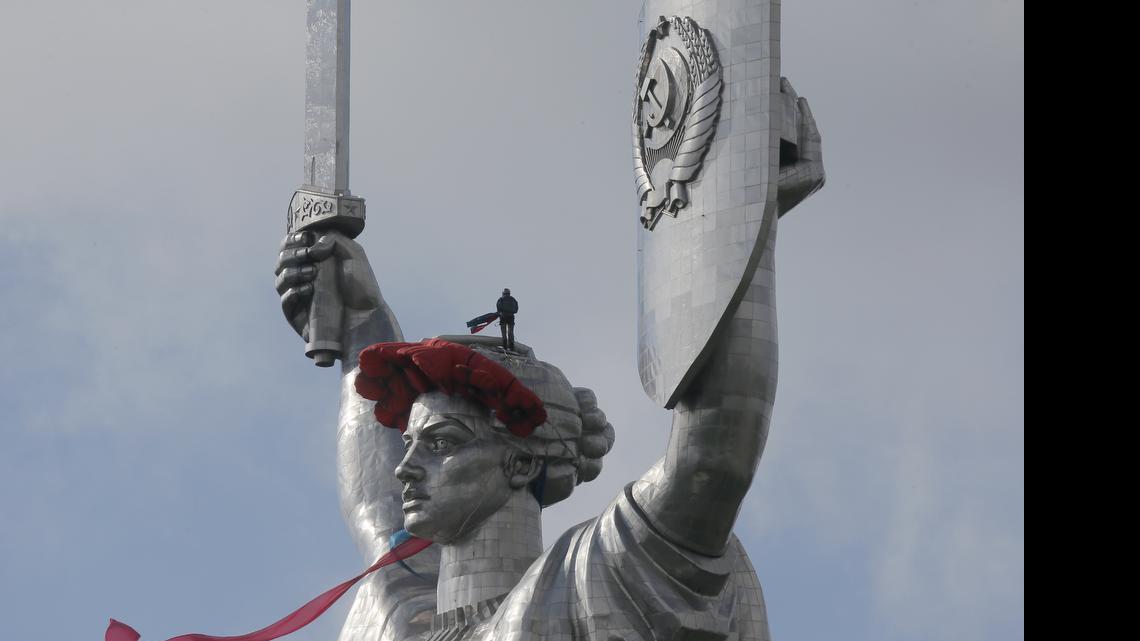 
A worker installs a wreath of poppies and red ribbon on top of the 330-foot Motherland Monument in Kiev, Ukraine, on Friday to mark the anniversary of the defeat of the Nazis in World War II. The Motherland Monument’s shield bears the Communist hammer-and-sickle, but maybe not for much longer. Ukraine’s leaders are eager to be seen as reinventing the nation and erasing all visible reminders of the communist past, they say, is an important step toward that goal. 
