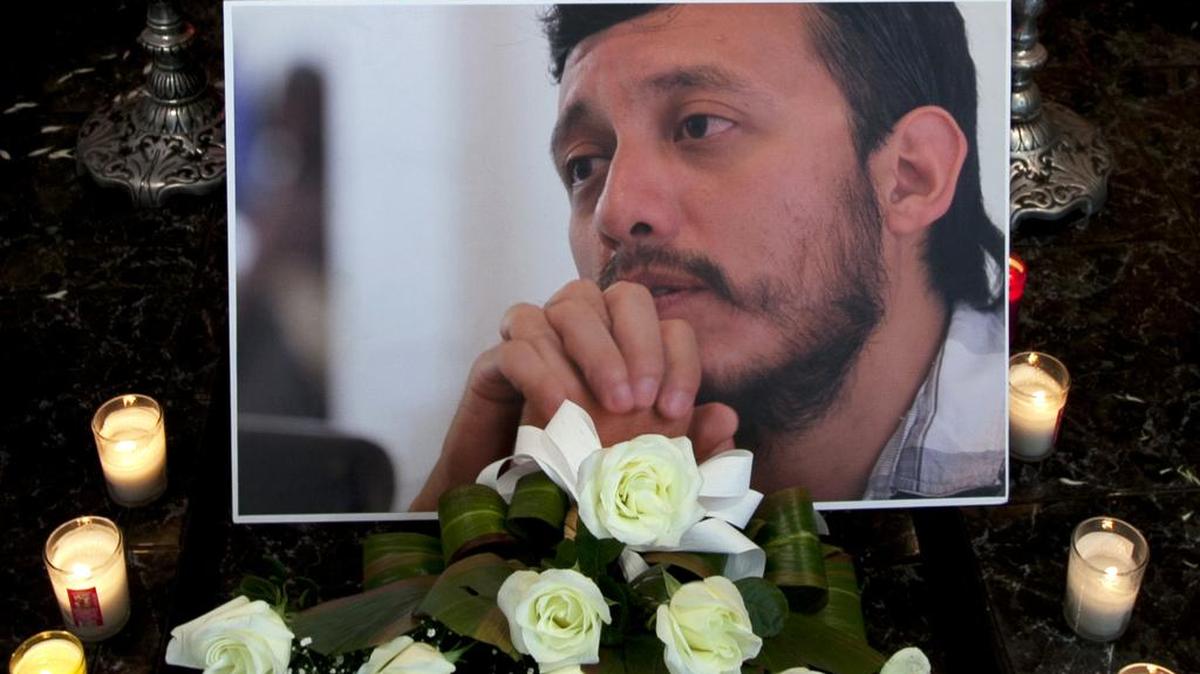 
A photo of slain photojournalist Ruben Espinosa sits among flowers and candles in front of his casket inside a funeral home in Mexico City on Monday. Espinosa, 31, who worked for the investigative magazine Proceso, was one of 37 journalists from Veracruz who have fled their state since 2000.
