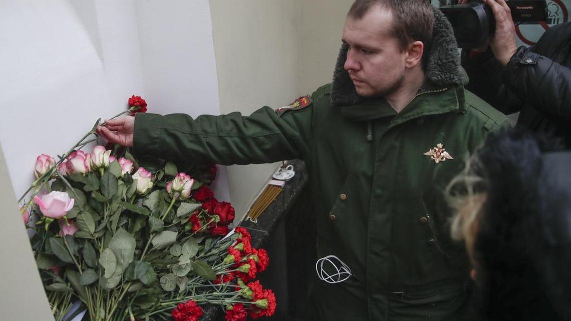 Alexander, a former member of the Alexandrov Ensemble, a well-known military choir, lays flowers at choir’s building in Moscow, Sunday, Dec. 25, 2016.