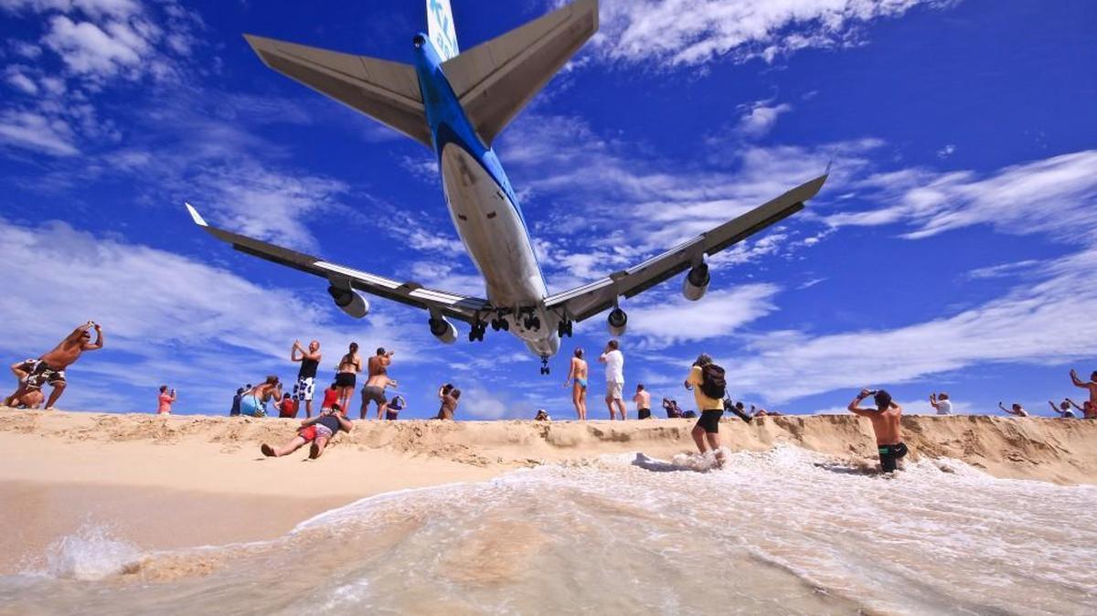 In this unrelated photo, an airplane is seen just before landing over a beach in Sint Maarten, a Caribbean island. A woman was killed Wednesday after she was blown by the jet blast from an airplane engine. The area is a tourist attraction because the airport runway is so near to the beach.