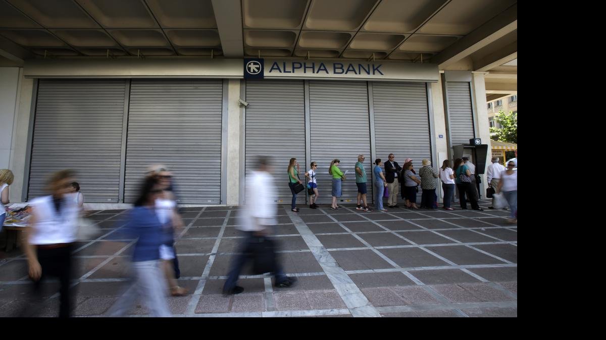 
People stand in a queue to use an ATM outside a closed bank in Athens, Tuesday, June 30, 2015. It's crunch time for Greece, with the European part of its international bailout expiring Tuesday and with it any possible access to the remaining rescue loans it contains that it needs to pay its debts. 
