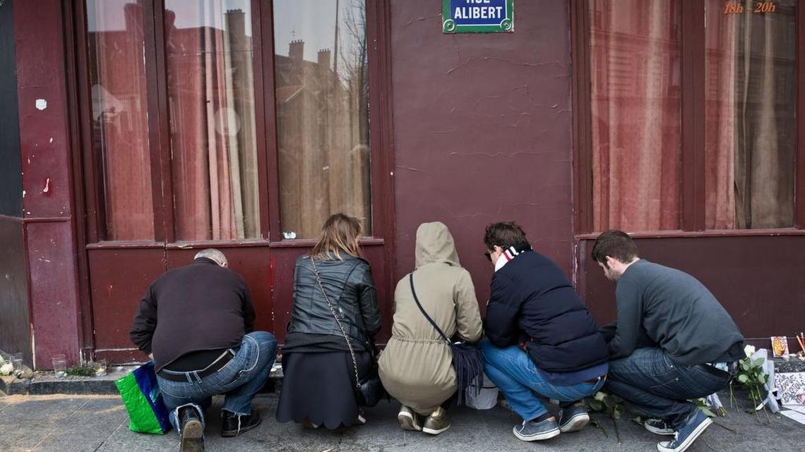 People laying flowers outside the Petit Cambodge and Carillon restaurants where at least 12 people were killed in Friday’s terrorist attacks.