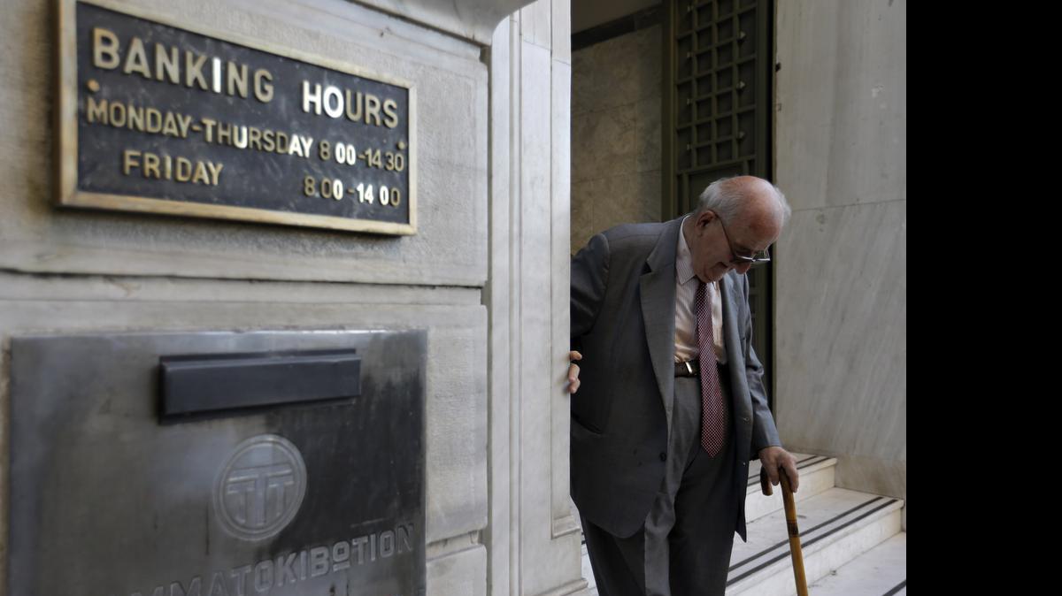 
An elderly man leaves a branch of the National Bank of Greece in Athens on Monday, July 20, 2015. Greek banks reopened that morning, but many restrictions on transactions, including cash withdrawals, remain. In addition, many goods and services have become more expensive as a result of a rise in Value Added Tax approved by Parliament the preceding week, among the first batch of austerity measures demanded by Greece's creditors. 

