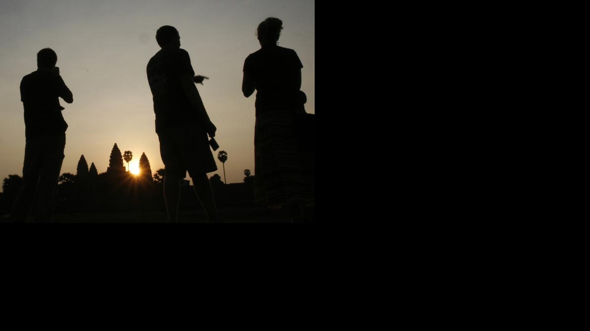 
Tourists talk as they wait to take pictures of sunrise in front of the famed Angkor Wat temple in northwestern Cambodia in March 2008. Cambodia’s most popular tourist attraction, the complex of ancient temples that includes Angkor Wat, is suffering from a form of overexposure as at least five foreign visitors have been arrested and deported this year for taking nude photos at the sacred sites.
