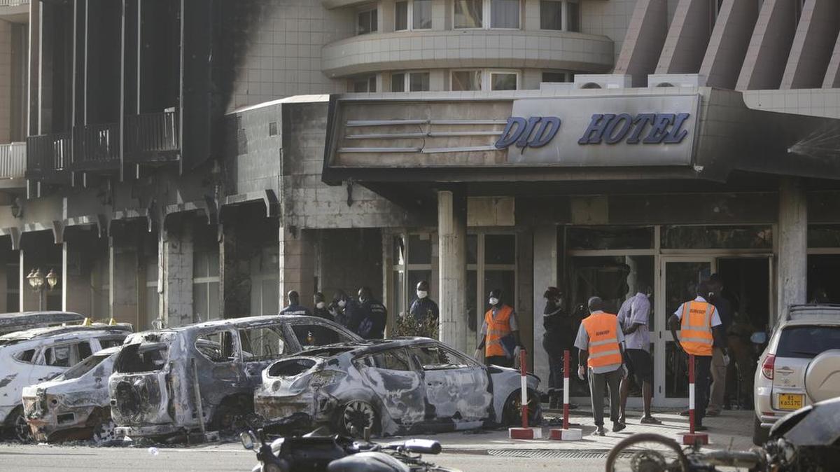 Rescue workers inspect damaged cars at the entrance of the Splendid Hotel in Ouagadougou, Burkina Faso, Jan. 16, 2016, after the overnight seizure of the luxury hotel in Burkina Faso's capital by al-Qaida-linked extremists ended.