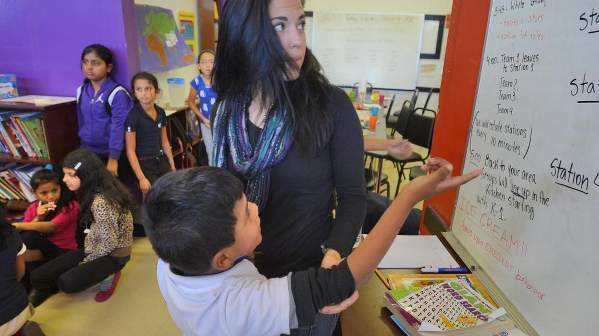 OurBRIDGE Executive Director Sil Ganzo listens to student Juan Carlos Diaz Lorenzo, age 7, in Charlotte, N.C., on Oct. 17, 2014. OurBRIDGE works with refugee and immigrant students. The students come to Charlotte from 22 countries. The program helps them with homework, provides English-language tutoring and creates an environment where they can learn from others going through the same experience.