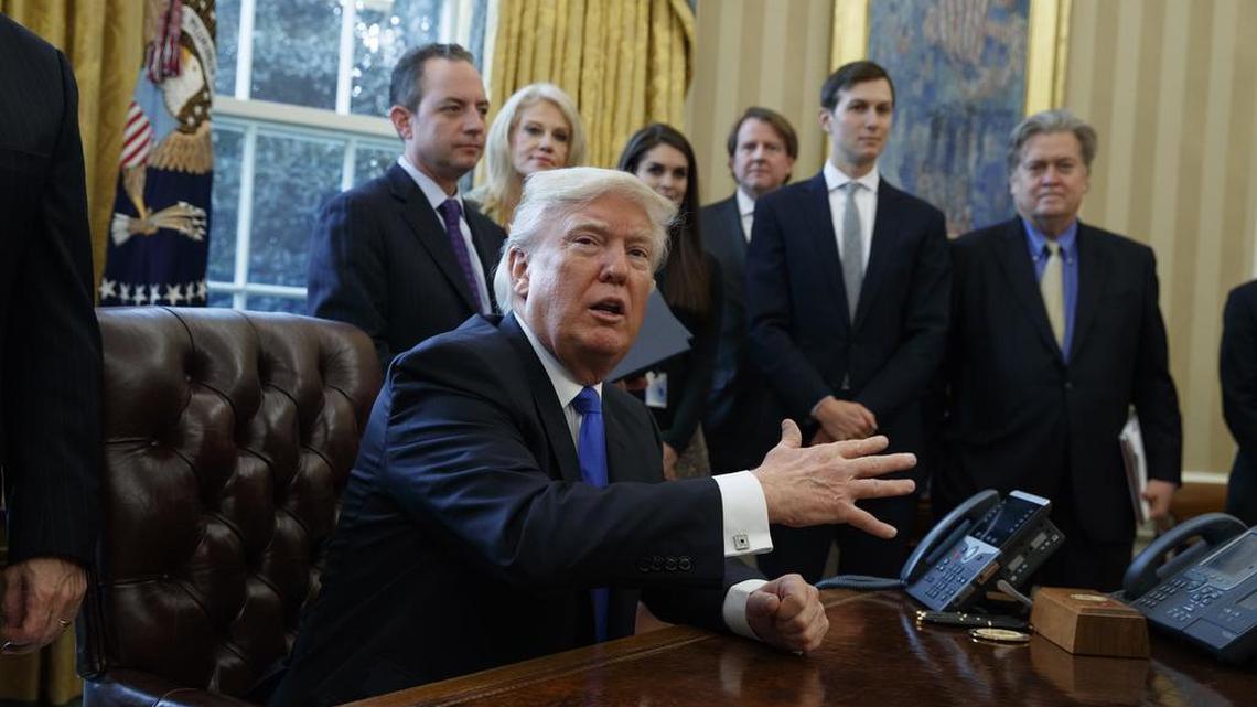 President Donald Trump talks with reporters in the Oval Office of the White House in Washington, Tuesday, Jan. 24, 2017.