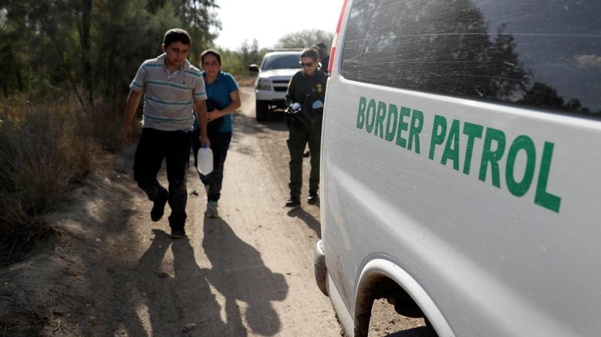 U.S. Customs and Border Patrol agents pick up immigrants suspected of crossing into the United States illegally along the Rio Grande near Granjeno, Texas on Aug. 11, 2017, photo.