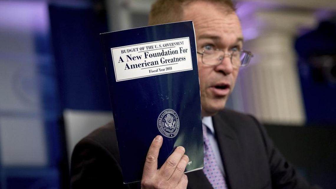 Budget Director Mick Mulvaney holds up a copy of President Donald Trump's proposed fiscal 2018 federal budget as he speaks to members of the media in the Press Briefing Room of the White House in Washington. Congress has restored many of the programs Trump proposed eliminating as it considers a host of spending bills.