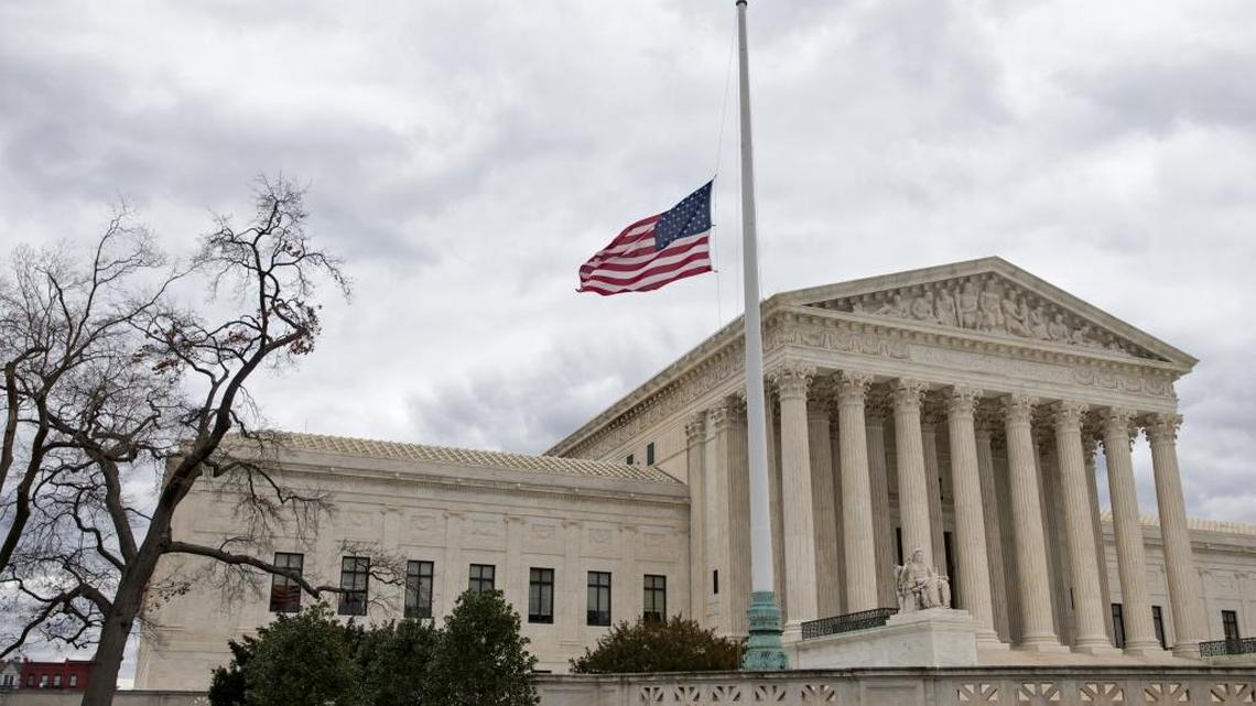 In this Feb. 25, 2016, file photo, in honor of Justice Antonin Scalia, a flag in the Supreme Court building's front plaza flies at half-staff in Washington.