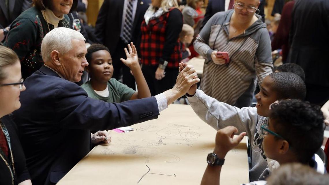 Vice President-elect Mike Pence high fives a student after they made Christmas tree decorations at the Statehouse Friday, Dec. 2, 2016, in Indianapolis.