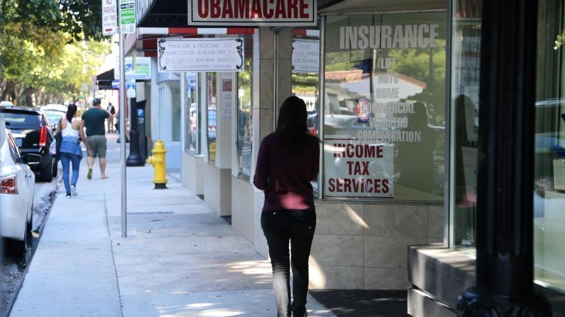 A woman walks past a sign advertising "Obamacare," Jan. 31, 2017, in Miami, Fl. President Donald Trump called the Affordable Care Act a “failed disaster” and told insurance company executives that the U.S. will replace it with “extraordinary” health care that will be “better than any other country anywhere in the world.”