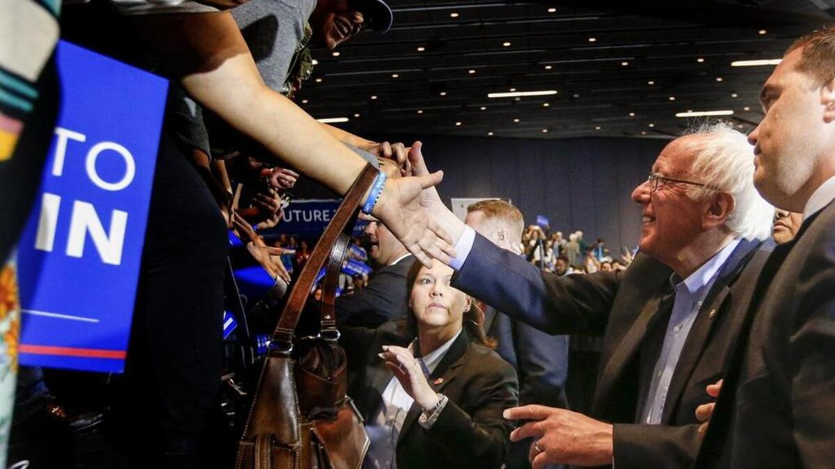 The crowd reaches out to shake hands with Democratic presidential candidate Bernie Sanders after a campaign rally at the Anaheim Convention Center in Anaheim, Calif., on Tuesday, May 24, 2016.