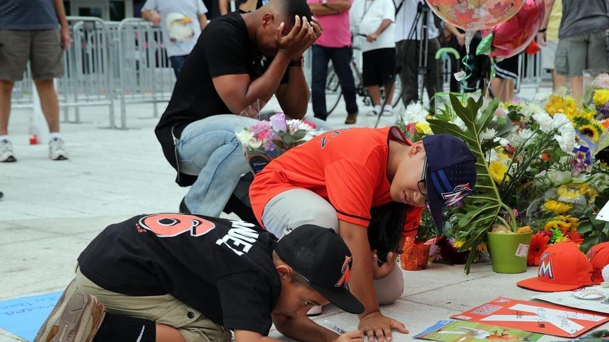 Fans Peyton Holton (front) and Shawn Lopez pay tribute by signing posters at a memorial for Miami Marlins pitcher Jose Fernandez, who died in a boat accident Sunday morning, at Marlins Park in Little Havana in Miami on Monday, Sept. 26, 2016.