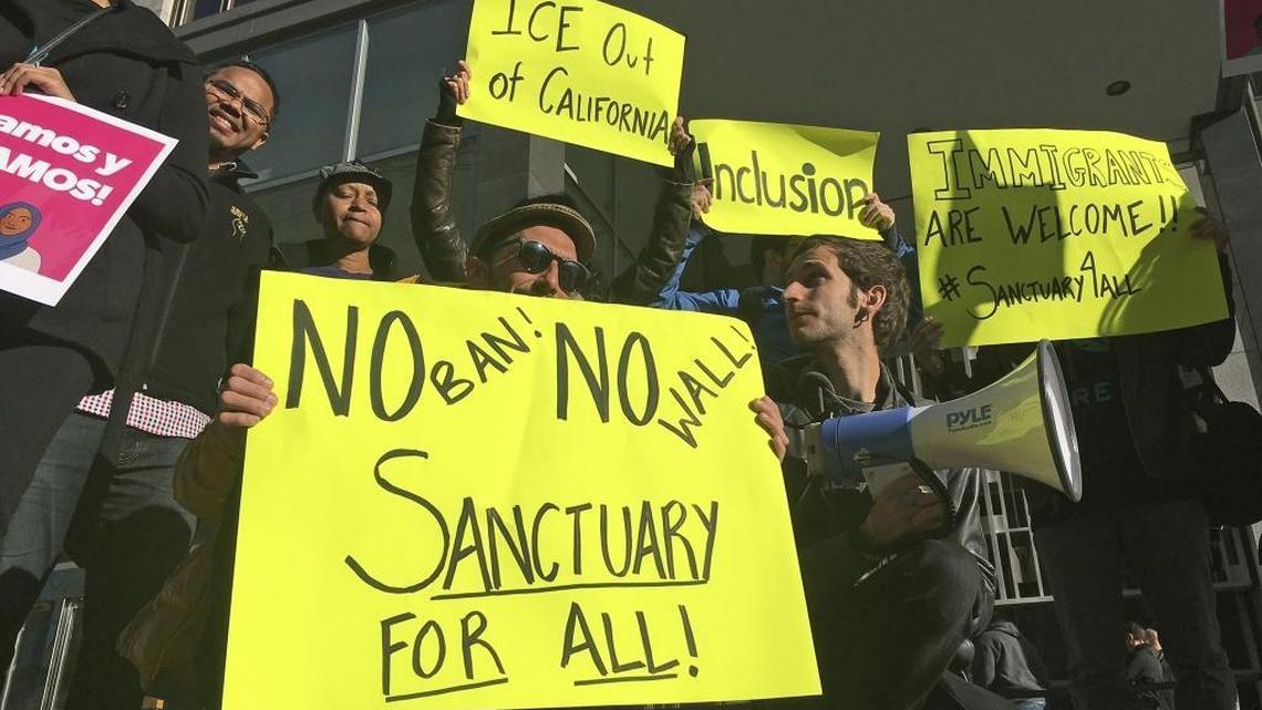 FILE - In this April 14, 2017, file photo, protesters hold up signs outside a courthouse where a federal judge will hear arguments in the first lawsuit challenging President Donald Trump's executive order to withhold funding from communities that limit cooperation with immigration authorities in San Francisco. A federal judge in San Francisco will not immediately require the Trump administration to award California a law enforcement grant that the administration has held over concerns the state does not comply with immigration law. U.S. District Judge William Orrick on Monday, March 5, 2018, rejected the state's request for a preliminary injunction to turn over the money.