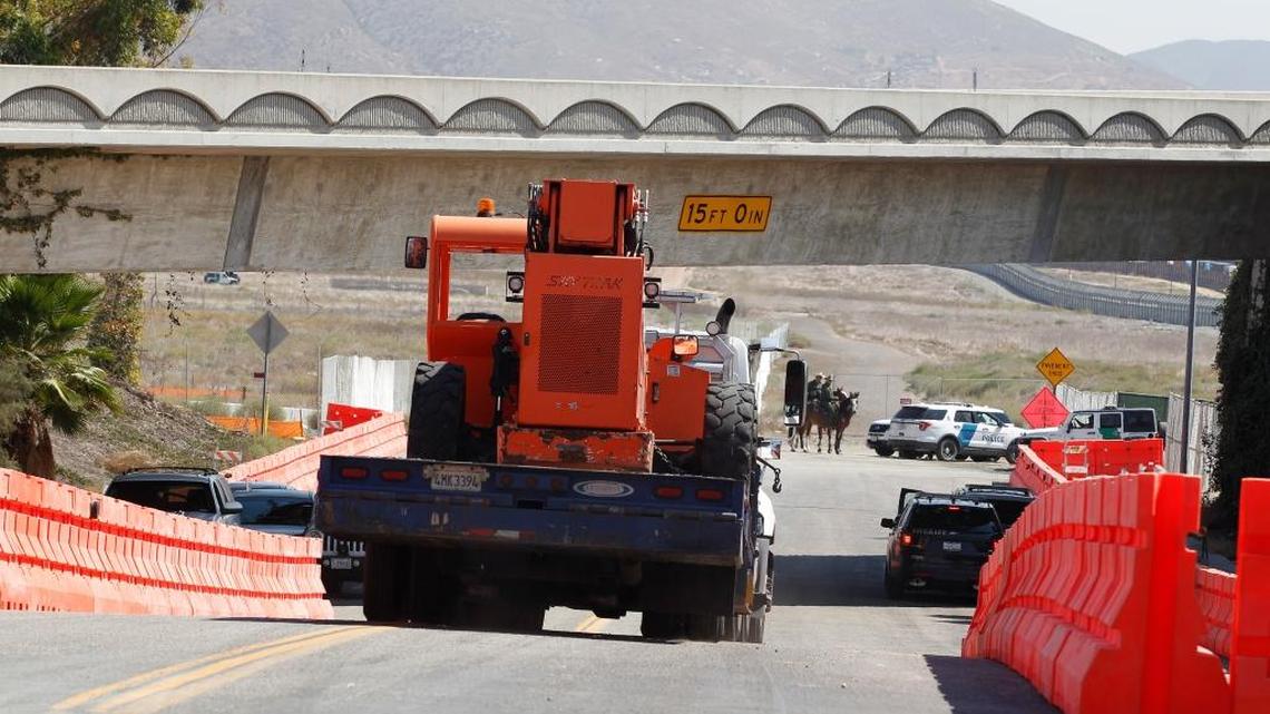 Heavy construction equipment is trailered in at the entrance that leads to where the prototype border walls will be constructed along the U.S.-Mexico border, on the corner of Enrico Fermi Drive and Via De La Amistad.