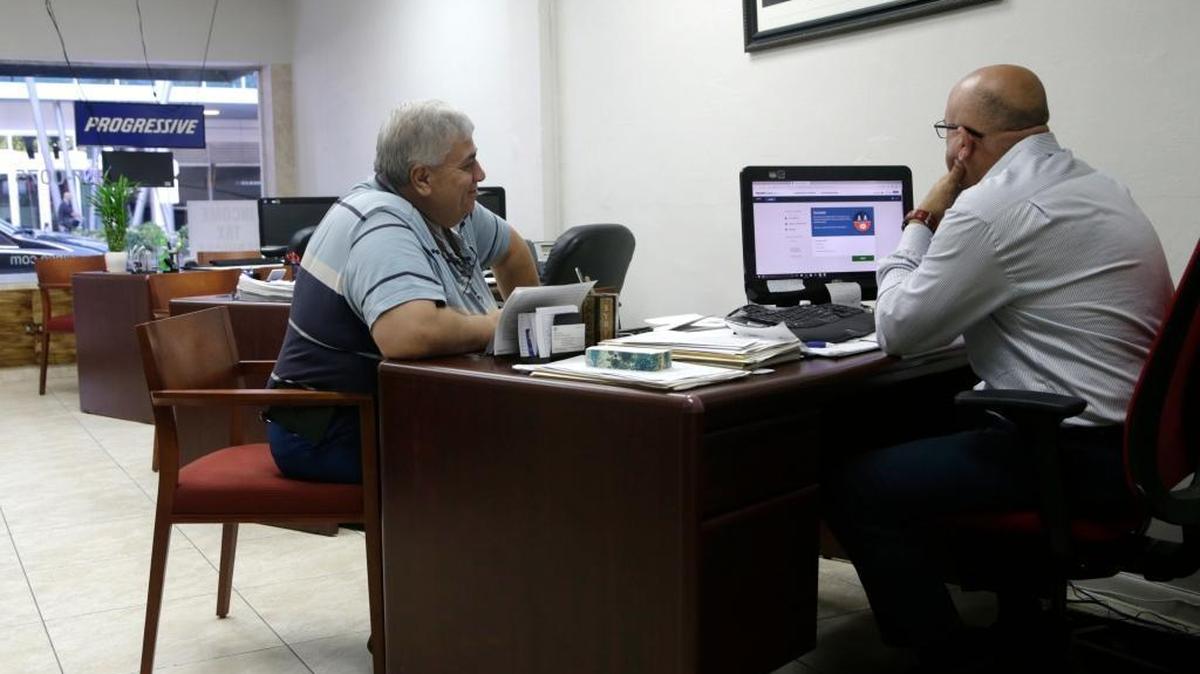 Sami Jamaleddine (left) signs up for health insurance offered under the Affordable Care Act with agent Michael Khoury in Miami. The Republican legislation to replace the ACA, which narrowly passed the House of Representatives, could spur an increase in “junk insurance” policies in states that opt out of two key Obamacare consumer protections.