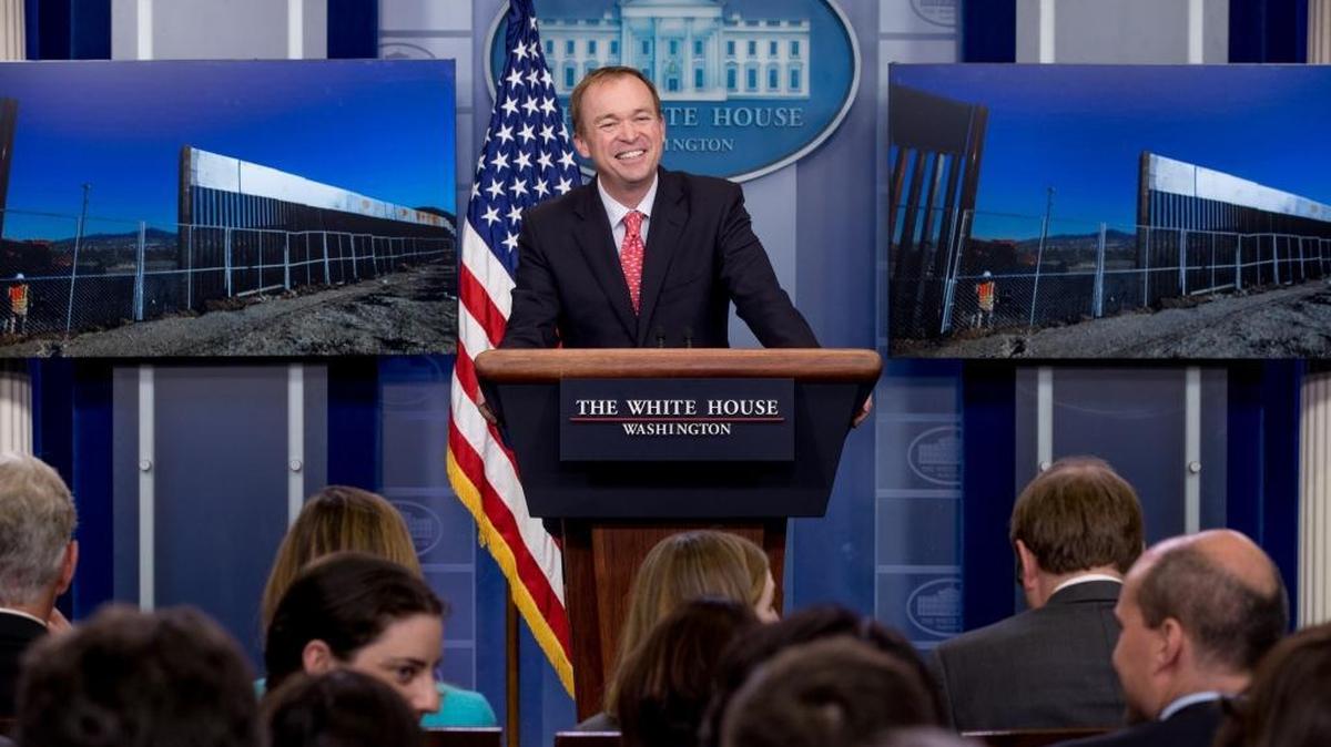 An image depicting different border walls is displayed behind Budget Director Mick Mulvaney as he speaks to the media during the daily press briefing at the White House, Tuesday, May 2, 2017, in Washington.