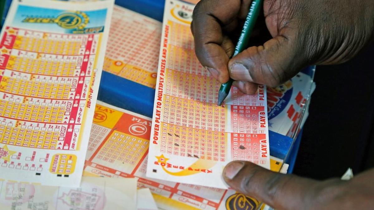 A player fills out his lottery ticket as people come out to buy Powerball lottery tickets at Colony Exxon in North Raleigh as the jackpot grows to $1.5 billion on Tuesday, Jan. 12, 2016.