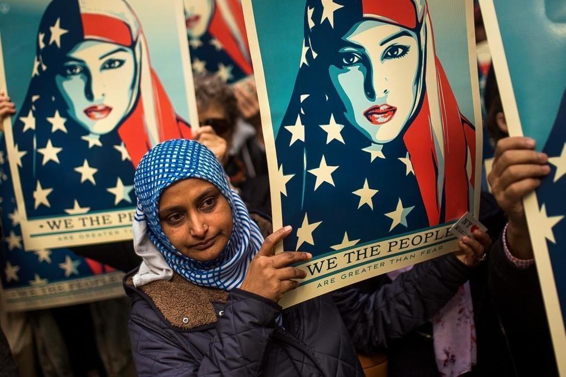 People carry posters during a rally against President Donald Trump’s executive order banning travel from seven Muslim-majority nations, in New York’s Times Square, Sunday, Feb. 19, 2017.