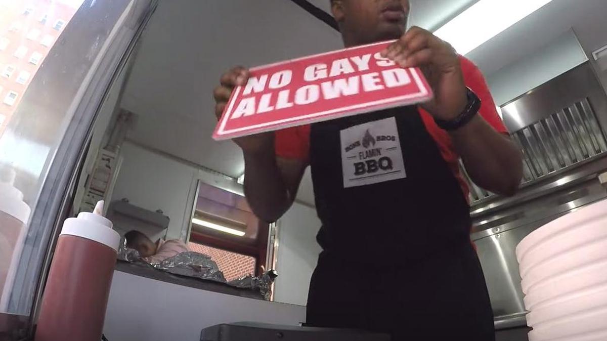 “Daily Show” correspondent Roy Wood Jr. posts a “no gays allowed” sign at a fake barbecue food truck while filming a segment on North Carolina’s HB2 law.
