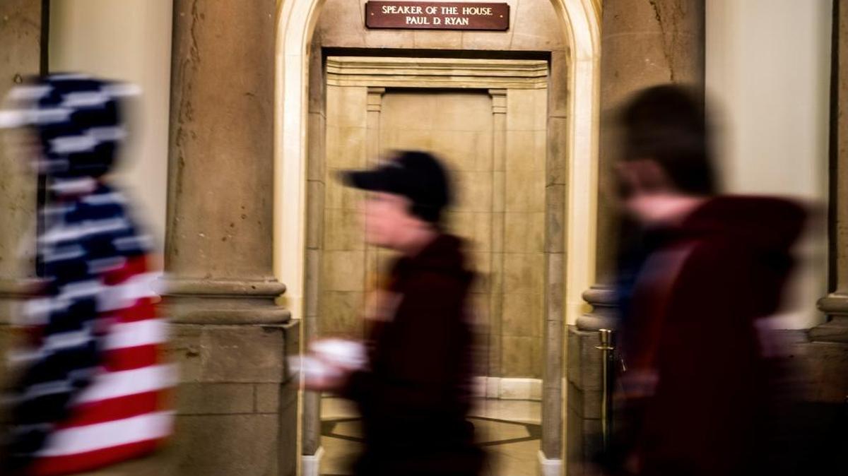 FILE – Tourists walk by House Speaker Paul Ryan's office. Two Republican lawmakers are hoping to change a federal law that allows former House speakers certain taxpayer-funded perks after leaving office.