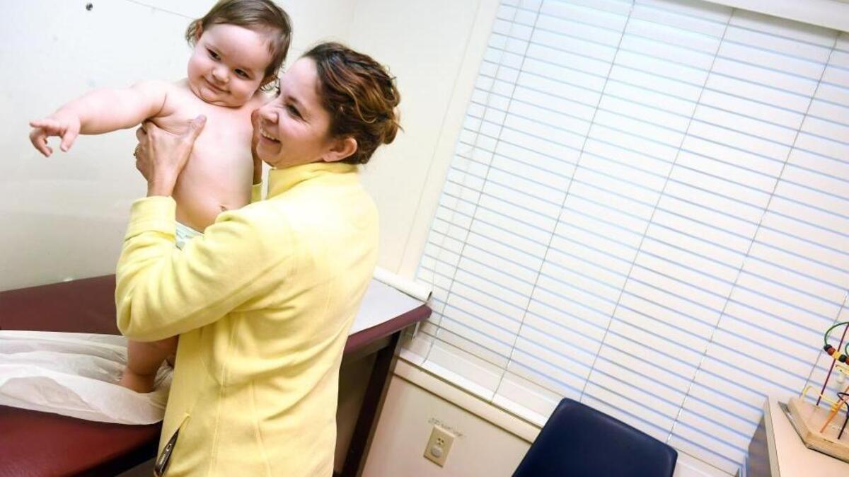 Marbell Castillo holds her granddaughter Maia Powell during the toddler's recent checkup at Burke Pediatrics in Fairfax County, Virginia. Maia is covered through the Children's Health Insurance Program.